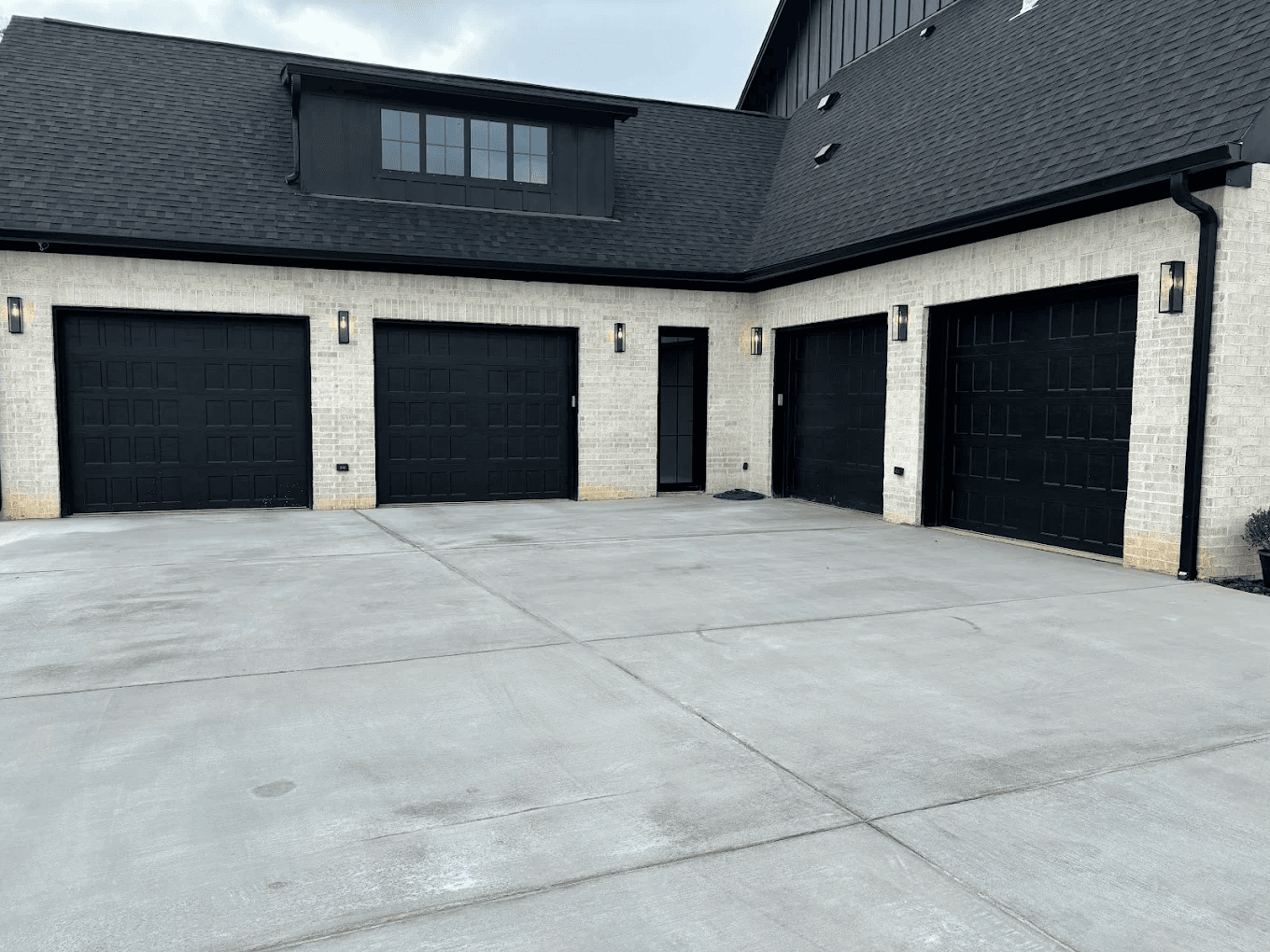 Modern black garage doors installed on a residential home in Alabama